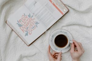 a person having coffee while reading a book