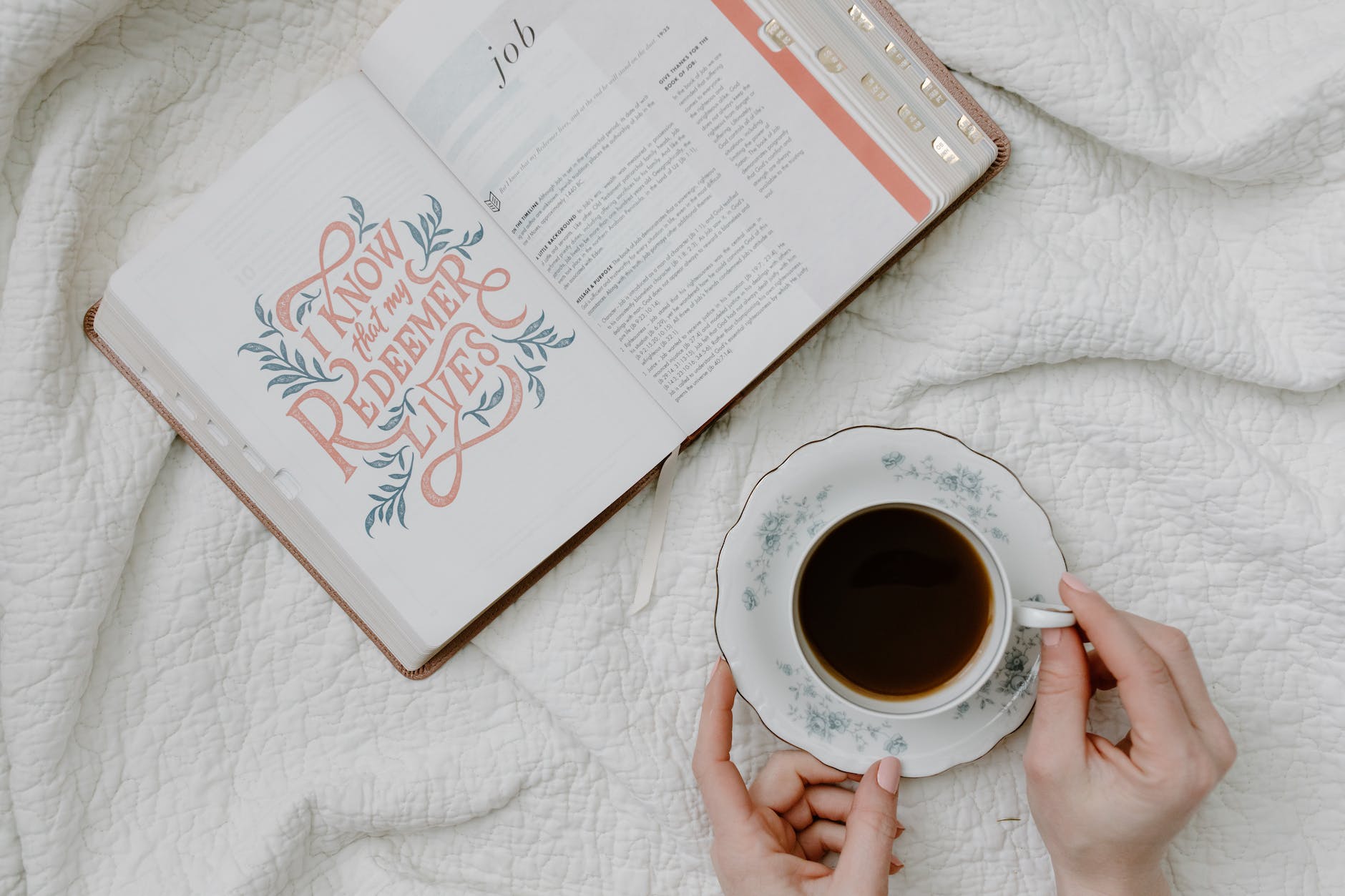 a person having coffee while reading a book